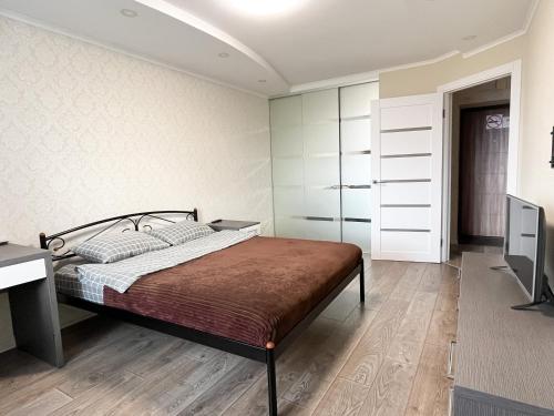 a bedroom with a bed and a desk and a television at 0147 квартира ЖК Щасливий, укриття в комплексі in Kyiv