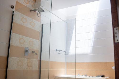 a glass shower in a bathroom with a sink at SANDS AND ROCKS APARTMENT in Mombasa