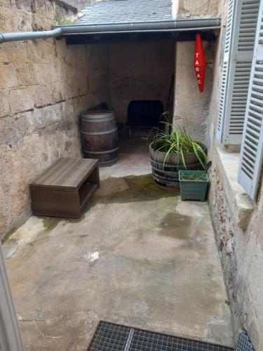 une terrasse avec un banc et un tonneau dans l'établissement Maison Bourgueil 3 chambres, à Bourgueil