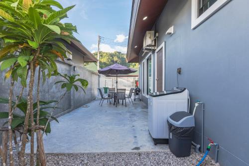 a courtyard of a house with a table and chairs at N&D Poolvilla in Ao Nang Beach