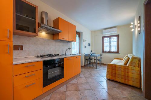a kitchen with orange cabinets and a stove top oven at Agriturismo Cantine Bevione - Rooms with air conditioning in Belvedere Langhe
