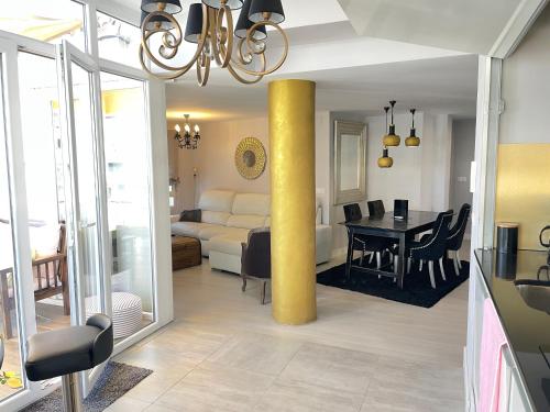 ein Wohnzimmer mit einer gelben Säule und ein Esszimmer in der Unterkunft Penthouse Luxury Granada in Granada