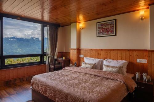 um quarto com uma cama com dois gatos sentados nela em StayVista's Himalayan Horizon - Mountain & Valley-View Villa with Heater em Gangtok
