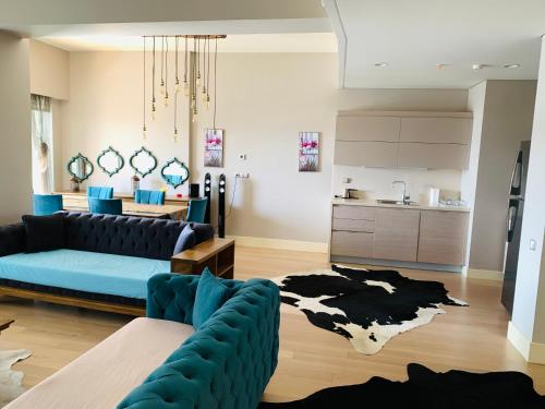 ein Wohnzimmer mit einem blauen Sofa und einem Kuhteppich in der Unterkunft Luxury Flat for Embassies & GM in Ankara