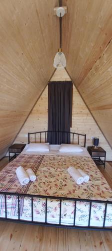 a bedroom with a bed with two pillows on it at oda lux nikorcminda in Ambrolauri