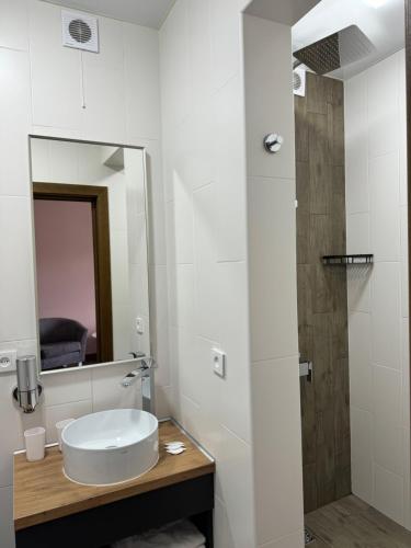a white bathroom with a sink and a mirror at Готель-ресторан Два Леви in Slavske
