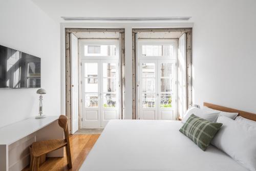 um quarto branco com uma cama e uma secretária em Avenida Viana Boutique Suites em Viana do Castelo