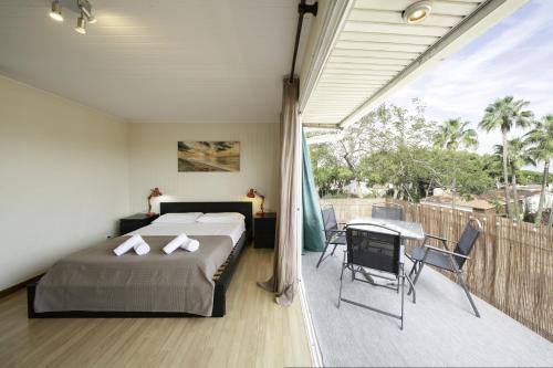 a bedroom with a bed and a table on a balcony at Luz y Color en Castelldefels in Castelldefels