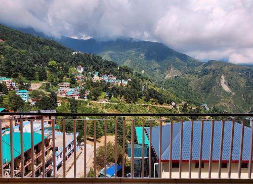 a view from the balcony of a resort with a mountain at The Bougainvillea, Mcleodganj in Dharamshala