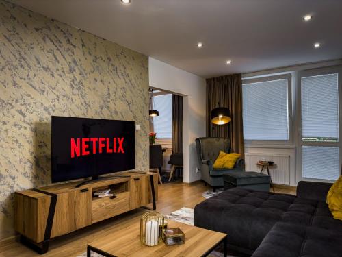 a living room with a tv and a couch at City Comfort Retreat in Nové Zámky