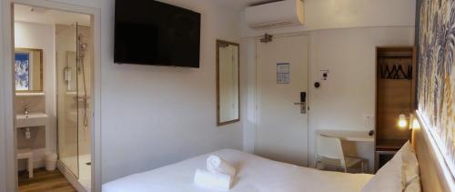 a white room with a bed and a television on the wall at KYRIAD DIRECT TOULON OUEST - La Seyne sur Mer in La Seyne-sur-Mer