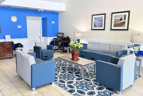a waiting room with blue furniture and a desk at Baymont by Wyndham Greenwood in Greenwood