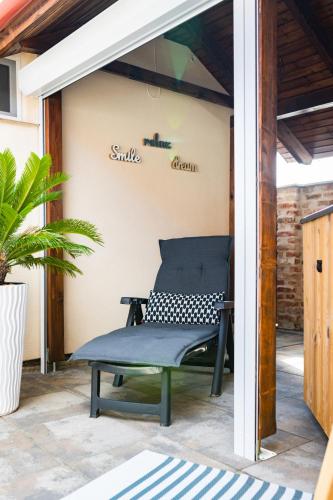 a patio with a bench and a sign on a wall at Lexi Apartman private HydroMassage Hot Tub Balatonboglár in Balatonboglár