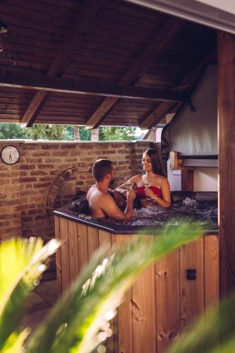 a man and a woman sitting in a hot tub at Lexi Apartman private HydroMassage Hot Tub Balatonboglár in Balatonboglár