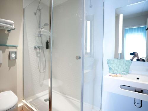 La salle de bains est pourvue d'une douche, de toilettes et d'un lavabo. dans l'établissement ibis Styles Quimper, à Quimper
