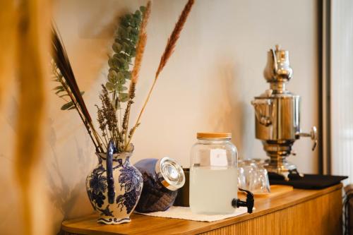 a wooden shelf with vases and a clock on it at Le Castel Cabourg hôtel & SPA- Restaurant La Calypso in Cabourg