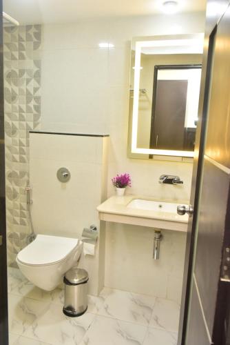 a bathroom with a toilet and a sink and a mirror at Hotel Royal Altis in Vasco Da Gama
