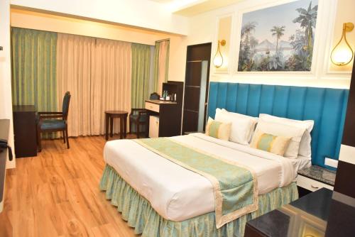 a hotel room with a large bed and a desk at Hotel Royal Altis in Vasco Da Gama