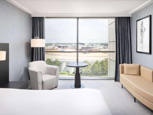 um quarto de hotel com uma cama e uma grande janela em Sofitel London Gatwick em Horley