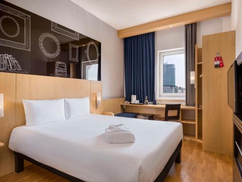 um quarto de hotel com uma cama grande e uma secretária em ibis Kyiv City Center em Kiev