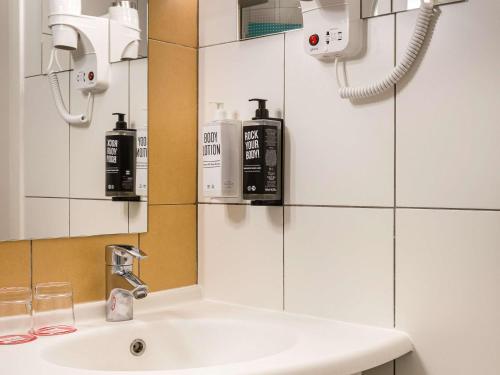 a bathroom with a sink and a mirror at ibis Kyiv City Center in Kyiv