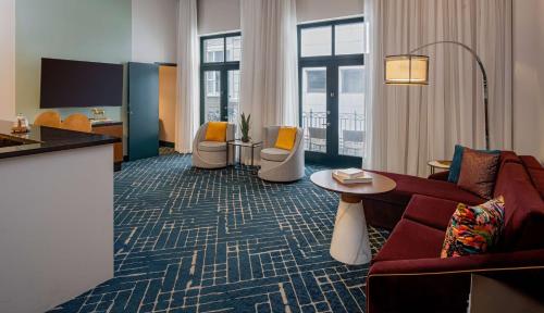 um quarto de hotel com um sofá, cadeiras e uma mesa em Hyatt Centric French Quarter em Nova Orleães