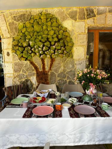 a table with food and a tree on the wall at Deghceni clubhouse in Dilijan