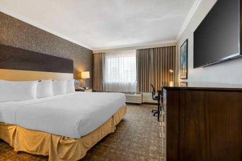 Best Western Los Angeles Worldport Hotel في ويلمنجتون: غرفة فندقية بسرير كبير وتلفزيون بشاشة مسطحة
