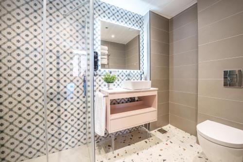 a bathroom with a shower with a toilet and a sink at Spirit Apartamentos Valladolid Centro in Valladolid