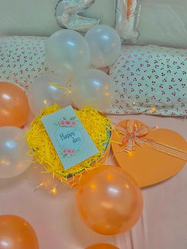 a table topped with balloons and a birthday cake at Homestay Tuyết Trinh in Nha Trang
