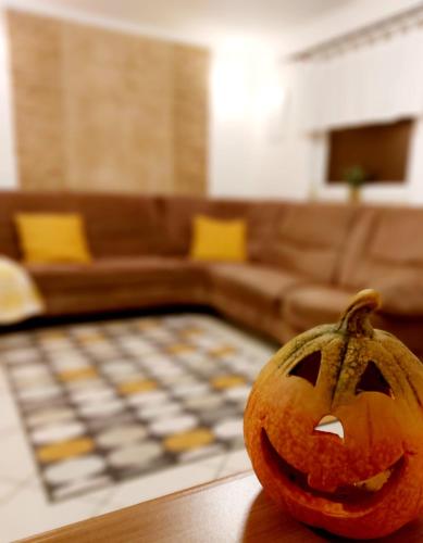 a carved pumpkin sitting on a table in a living room at Lexi Jakuzzis Apartman Balatonboglár in Balatonboglár