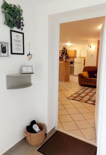 a hallway leading to a living room with a couch at Lexi Jakuzzis Apartman Balatonboglár in Balatonboglár