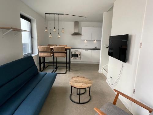 a living room with a blue couch and a table at Home sweet home Arnhem in Arnhem