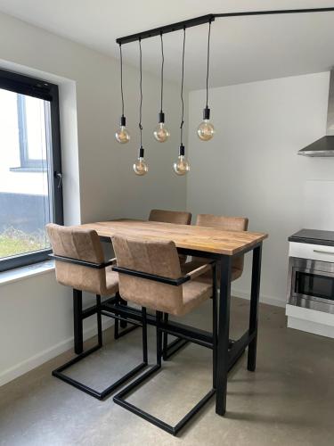 a dining room table with chairs and lights at Home sweet home Arnhem in Arnhem