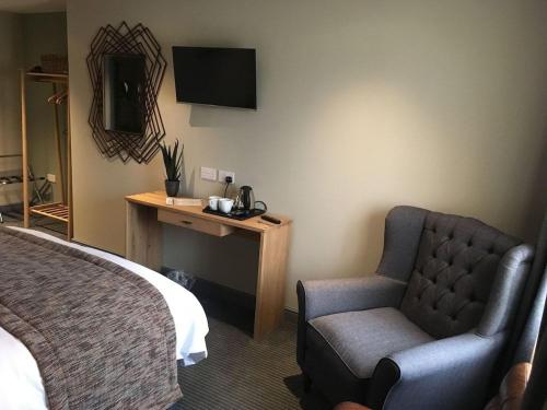 une chambre d'hôtel avec un lit et une chaise dans l'établissement The New Hobbit Hotel Rooms, à Halifax