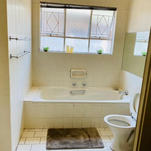 a bathroom with a bath tub and a toilet at Eden homestay in Edenvale