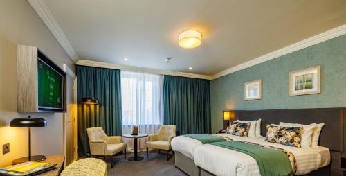 a hotel room with a bed and a television at Mount Wolseley Hotel Spa & Golf Resort in Tullow