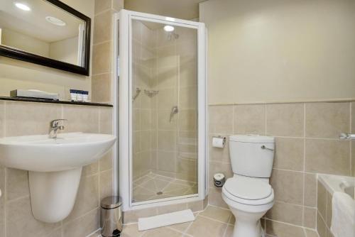 een badkamer met een toilet, een wastafel en een douche bij Protea Hotel by Marriott Mahikeng in Mahikeng