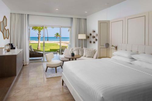 een slaapkamer met een bed en een woonkamer met uitzicht op de oceaan bij Hyatt Regency Grand Reserve Puerto Rico in Rio Grande