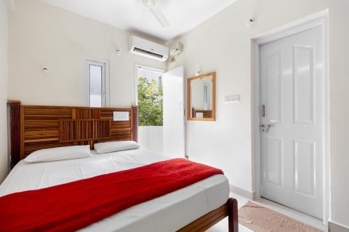 a bedroom with a bed with a red blanket at Stayhome Suites in Bengaluru
