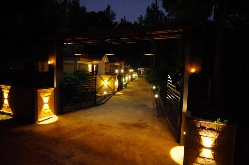 a gate to a house at night with lights at RICHBERRY- A Premium Plantation Villa's in Suntikoppa