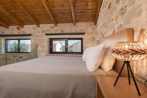 a bedroom with a bed in a stone wall at Evylio Stone Houses in Lithakia