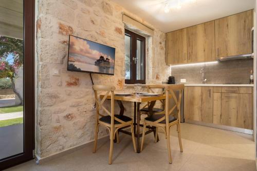 a kitchen with a wooden table and chairs at Evylio Stone Houses in Lithakia