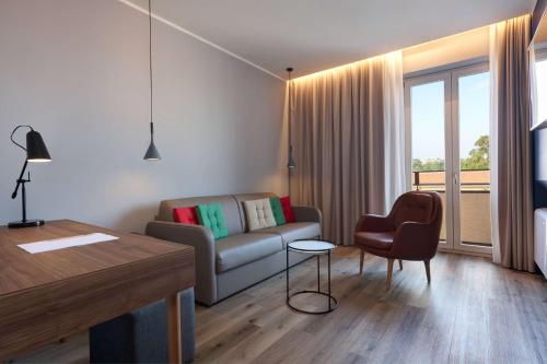 a living room with a couch and a chair at Radisson Hotel Ferrara in Ferrara
