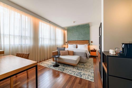 a hotel room with a bed and a chair at Canopy By Hilton Sao Paulo Jardins in Sao Paulo