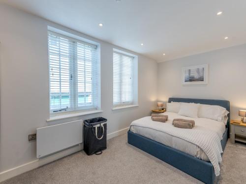 a bedroom with a large bed and two windows at Pass the Keys 1 bed 40D Dahlia Contemporary town centre apartment in Shrewsbury