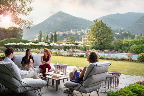 a group of people sitting in chairs on a patio at Casa Bianca Apartments in Como