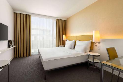 a hotel room with a large bed and a desk at Vienna House by Wyndham Andel's Prague in Prague