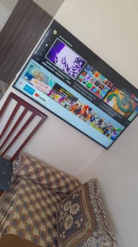 ein Monitor hängt an einer Wand über einer Couch in der Unterkunft تطوان in Tétouan