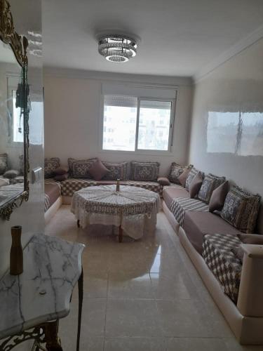 ein Wohnzimmer mit einem Sofa und einem Tisch in der Unterkunft تطوان in Tétouan